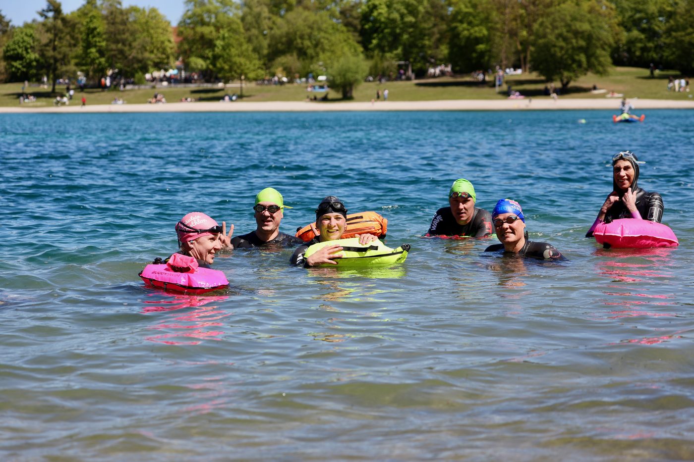 Lachende Gruppe von Freiwasserschwimmer:innen im See